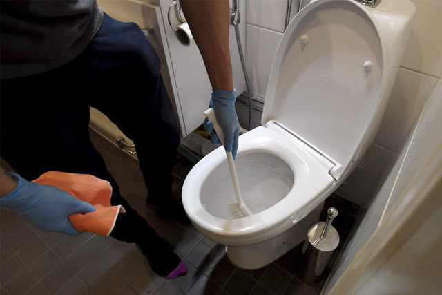 清潔公司員工正在清潔洗手間。