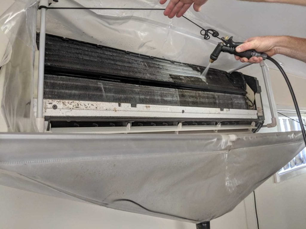 清潔公司員工在洗冷氣的散熱鋁片。