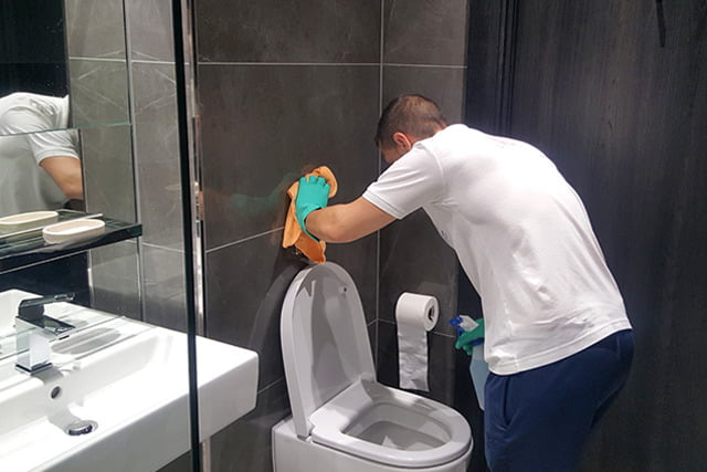 清潔公司員工正在進行入伙清潔洗手間。