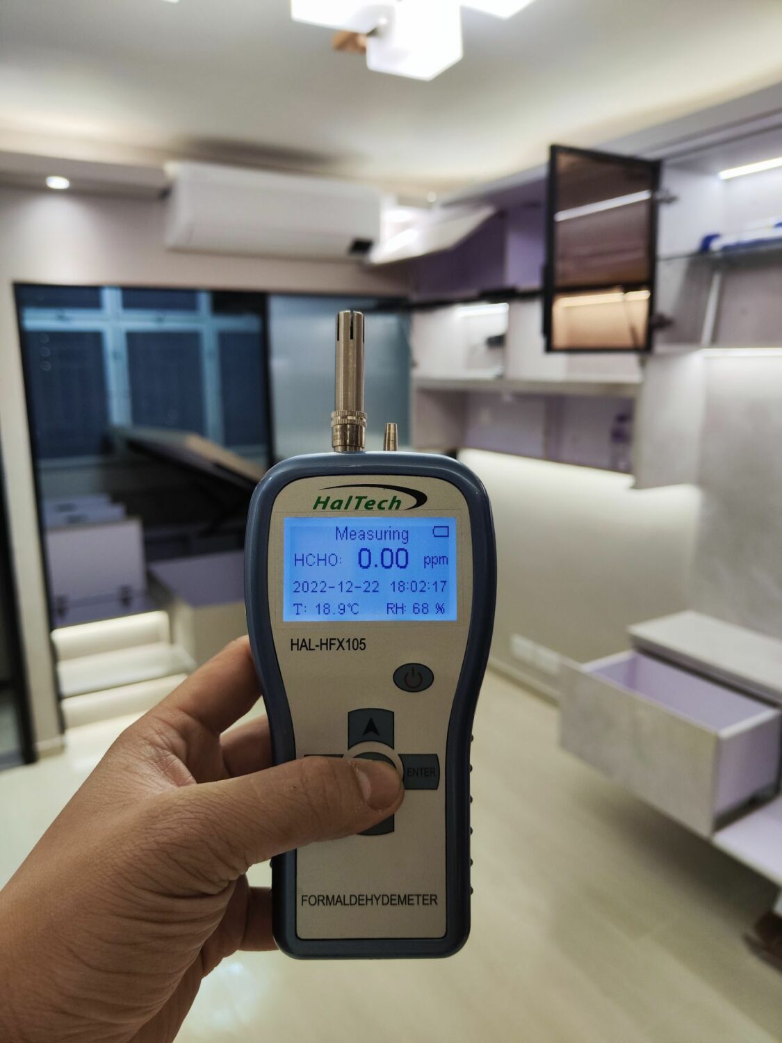 除甲醛服務後，一個人在房間裡拿著一個甲醛測量儀器。